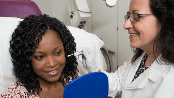 Dermatologist consulting with a patient with dark skin. Dermatologist consulting with a patient with dark skin.